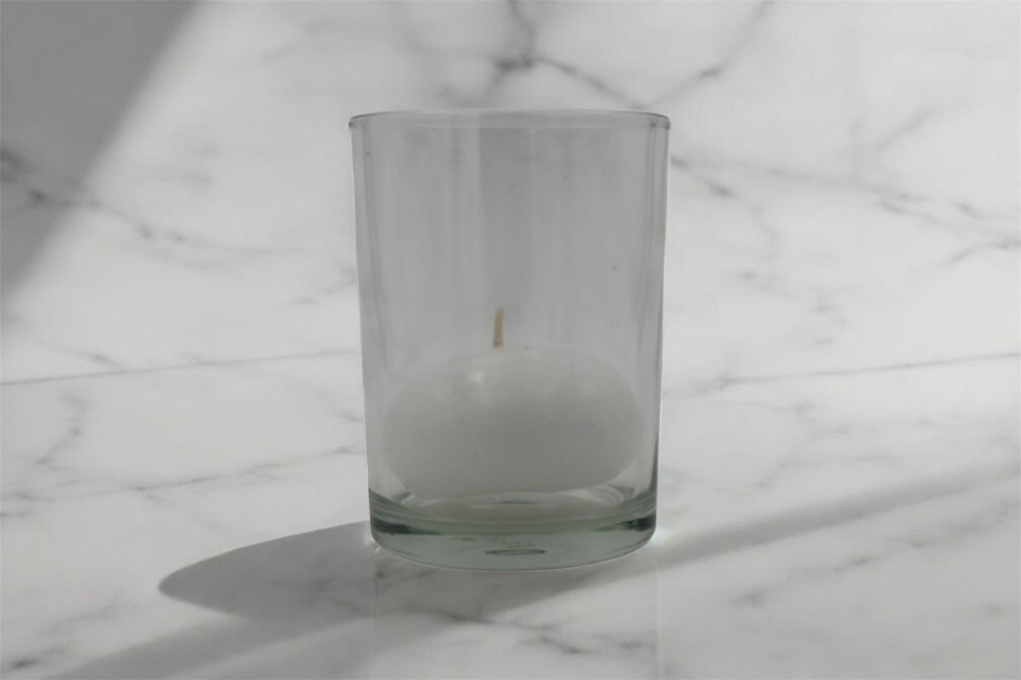 Vela flotante blanca en vaso de cristal reutilizable