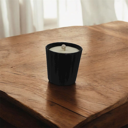 Vela aromática de cera de soya en vaso votivo de cristal negro